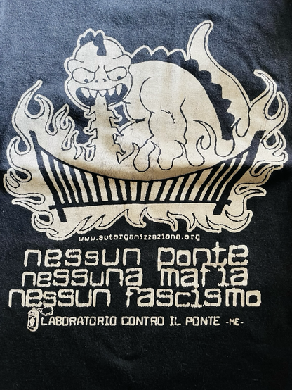 Parte davanti di t-shirt nera con stampato bianco che rappresenta un drago bianco e un ponte avvolto da fiamme e l’indirizzo www.autorganizzazione.org sotto le scritte nessun ponte Messina mafia nessun fascismo laboratorio contro il ponte -me