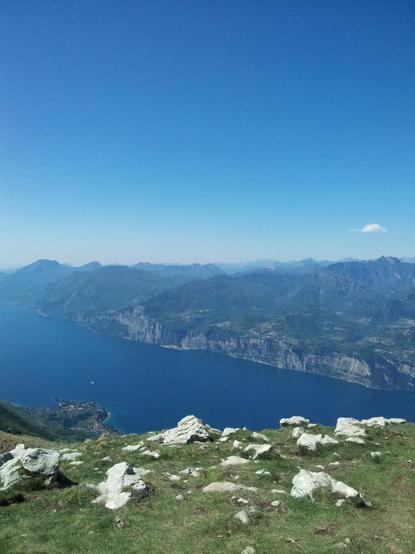 Das Bild zeigt eine atemberaubende Landschaft mit einem tiefblauen See, der sich durch eine Reihe von Bergen schlängelt.