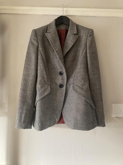 Grey wool single breasted blazer. It’s got interested slanted pocket flaps. Above the waist (and the sleeves) it’s actually a black and white prince of wales with a red overcheck. Below the waist a simple black and white houndstooth.