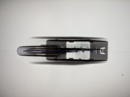 X-ray image of an object. It's dark on a white background. Rectangular in shape, long side horizontal with some spiky bits pointing left.