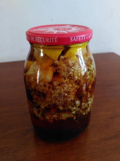 The same glass jar has been filled with brown transparent liquid and closed with a red cap.