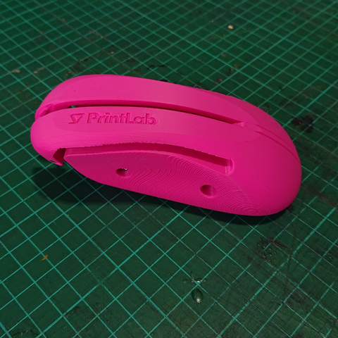 What looks like a pink cordless computer mouse, but is actually a 3D print of a pen holder, where a pen can be clamped between the "mouse buttons" and when they're pressed the pen would make contact with the surface the pen holder is placed on.

It makes it easier for people who have trouble gripping a pen to be able to use one.