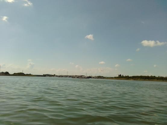 From the dinghy looking west towards the boatyard as an easyJet plane comes in to land