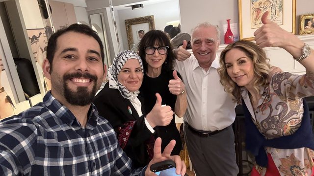 Group photo - 5 people in a living room setting smiling towards the camera doing the ‘thumbs up’ sign. The man closest to the camera is Mosab Abu Toha. Another man in the photo is Martin Scorsese