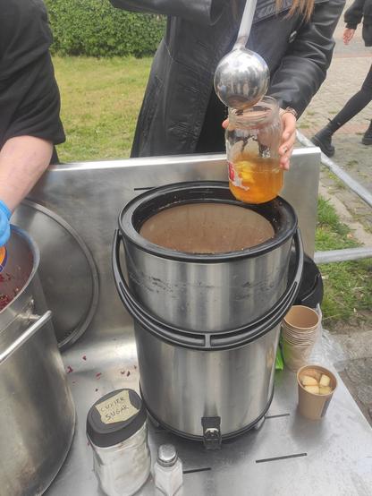 Do słoika jest nalewany kompot z dużego termosu