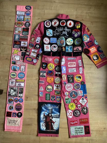 The other half of the scarf and the back of the garment. The back panel is black instead of pink. It's also all covered in patches.