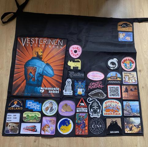 A black half-apron about 2/3 covered in patches