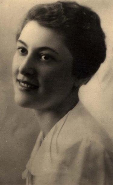 A studio portrait of the face of a young woman. She turns her