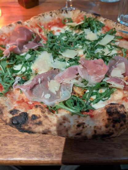 Pizza romagnola: rucola, prosciutto crudo, scaglie di grana, mozzarella, pomodoro.