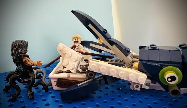Lego Stede in a rowboat looking terrified as a giant kraken attacks his boat. Lego MerKraken Ed looks on, facing away from the camera.