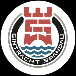 Das Logo von Eintracht Spandau: Im Zentrum abgebildet ist stilisiert ein roter Turm der Zitadelle Spandau, der aus den Buchstaben E und S aufgebaut ist. Unter dem Turm sind die blauen Wellen der Havel dargestellt, die durch Spandau fließt. Kreisrund eingerahmt wird das Logo durch die Schrift "Eintracht Spandau" in weißen Buchstaben auf schwarzem Hintergrund.