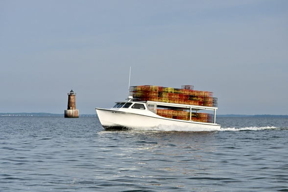 Blue sky. Blue water. Crab boat piled high with colorful crab pots. The Bloody Point lighthouse in the background