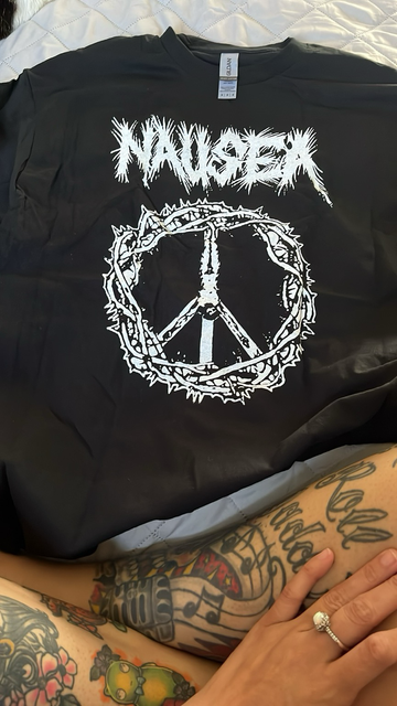 Black Nausea band tee shirt with a peace sign made of a crown of thorns. A crucified Jesus makes the inside of the peace sign. The nausea band logo is adorned across the top of the shirt. All designs in white ink.