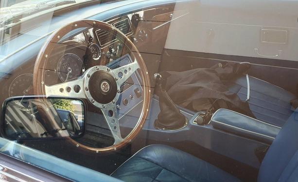 view into the cockpit through the glass
wooden wheel, blue leather seats, fancy
