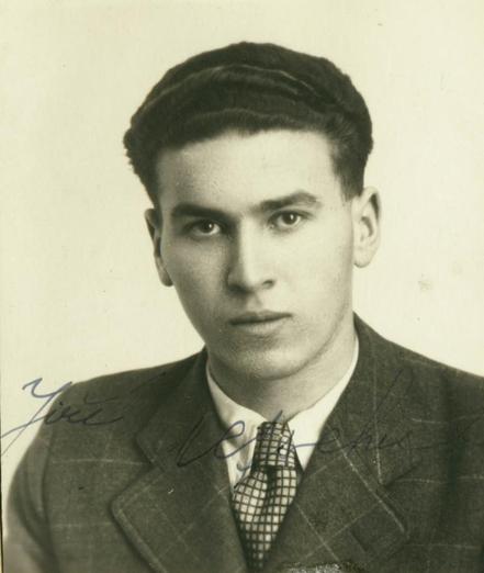 A portrait ID-style photo of a young man in a suit. He has dark short hair.