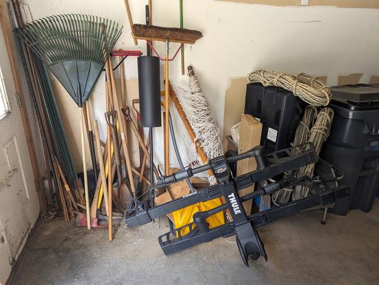 * BEFORE *
Yard tools piled all on top of each other in the corner of the garage with a bike rack blocking access to some of them and a bunch of stuff stacked on the yard cart.