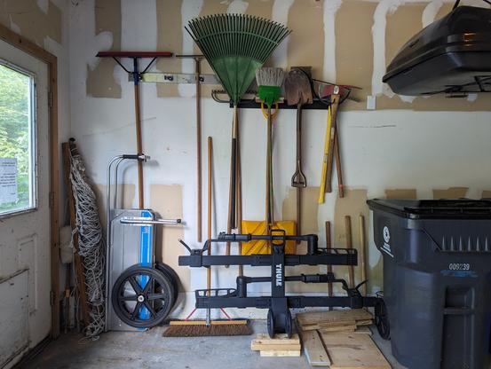 * AFTER *
Neatly organized yard tools, hanging on the wall. The bike rack is still in front of them, but it's back against the wall, and the tools are high enough - but not too high - to reach them over the bike rack.