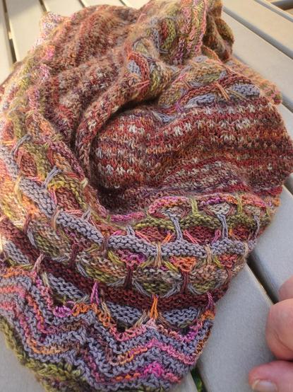My mostly brown-toned Aurora Cabin shawl, a total workhorse, bunched up on an outdoor grey slatted table