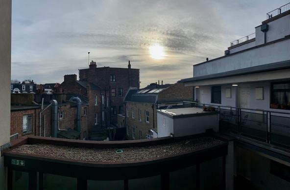 Panoramic of a building in North London, with a low sun. Taken with a phone.