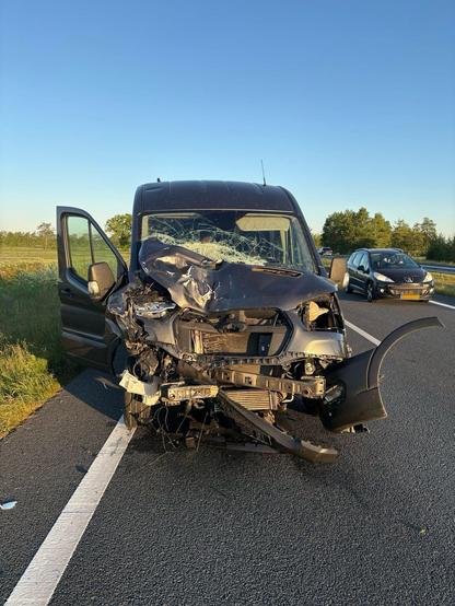 Een flink beschadigde bestelbus staat op de N31 bij Drachten na een ongeval met een bus