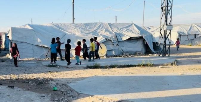 Des enfants au milieu d’un camp.