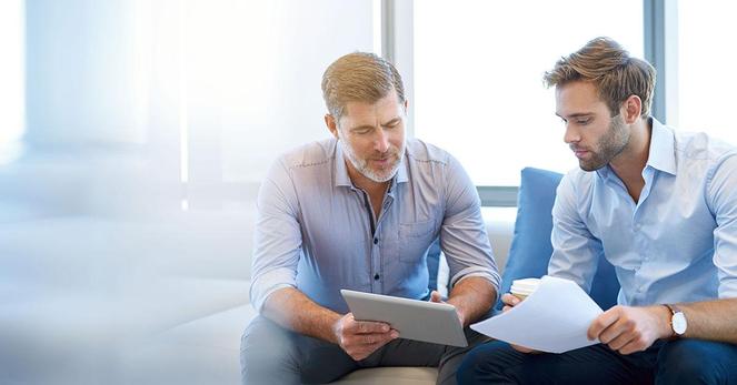 A stock image of two men comparing notes.