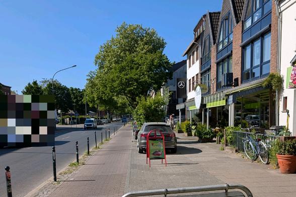 Radweg und Gehweg sind durch Poller von der Fahrbahn abgegrenzt. Die Poller haben jedoch einen so großen Abstand, dass Autos dazwischen durch passen und zwischen Radweg und Gehweg parken.