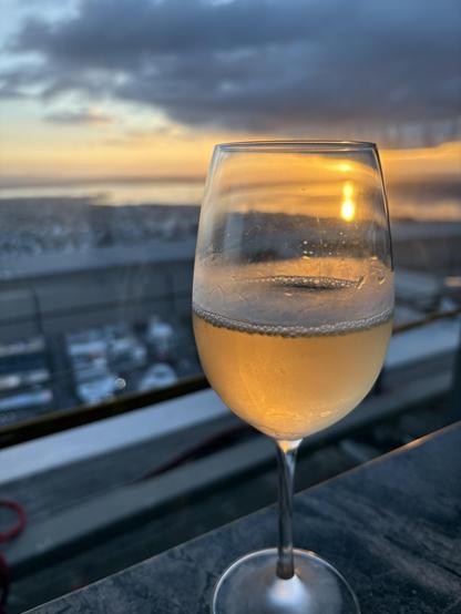 A glass of wine with the sunset in the background
