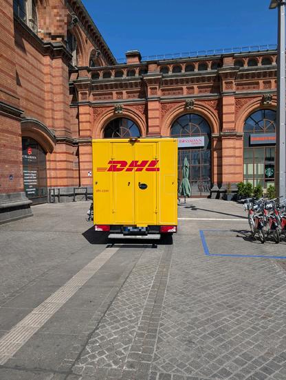 DHL-Lieferwagen steht genug auf der Ecke des Blindenleitsystems am Bremer Hauptbahnhof