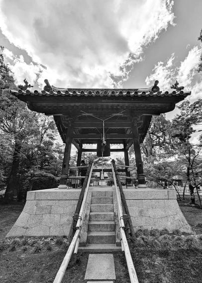 A big temple gong in the center of the picture. the stairs with bamboo support on either side lead  lead to the gong