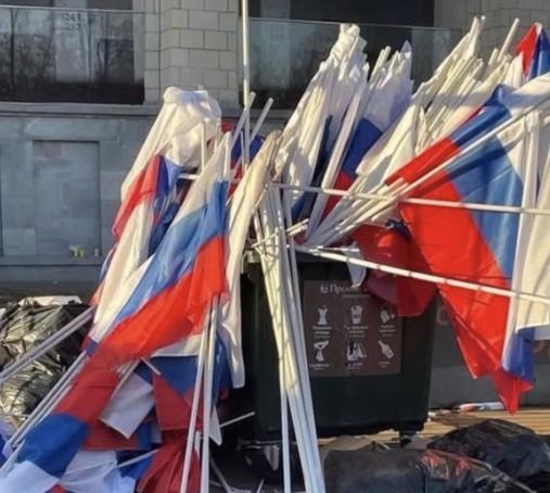 A dumpster full of discarded russian flags