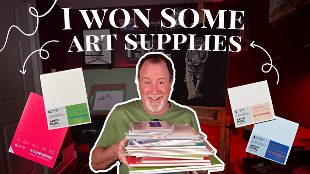 Mike Hendley smiling in green shirt holds a tall stack of Legion Paper pads and panels; bold text reads 'I WON SOME ART SUPPLIES' with product images floating around him.
