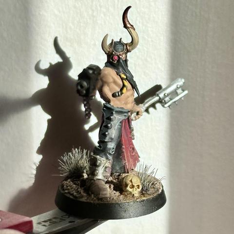 A lovingly painted Chaos Cultist model from Warhammer 40K. Set again a dark shadow from the sunlight.