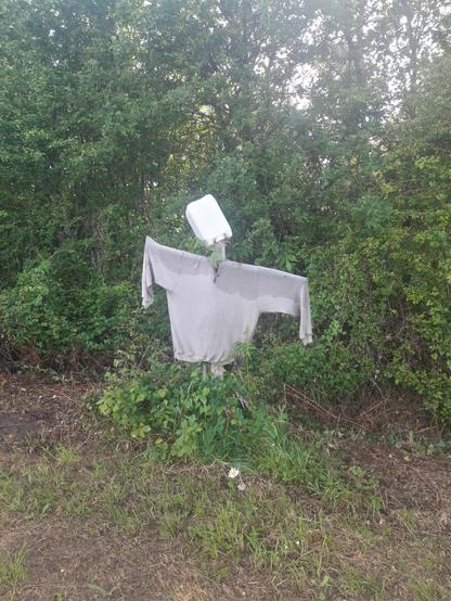 A scarecrow assembled from an old sweater, a jerrycan and some bits of wood.