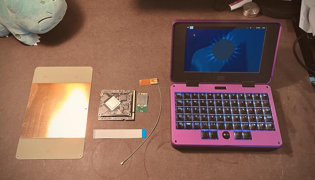 Small chunky laptop next to a small circuit board, another even smaller board and a large PCB plate that's half covered with a copper layer