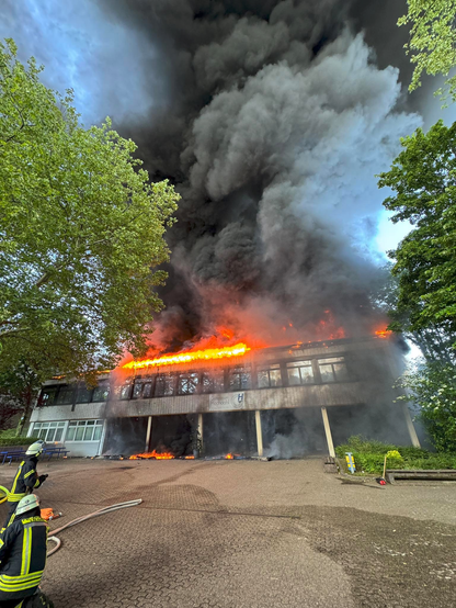 Eingang am Gymnasium mit brennendem Dach