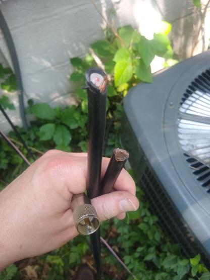 Left hand holding a severed length of RG-213/U