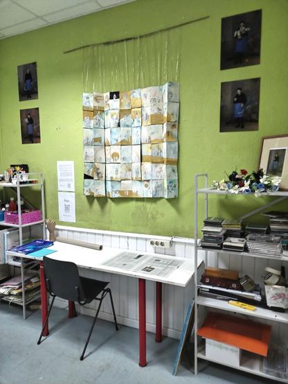 An artist workshop full of stuffs. In the green wall you can see the photos and the draw.