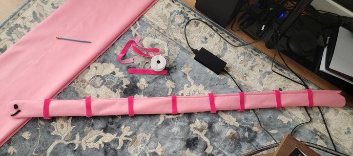 An irl picture of a pink worm scarf in progress