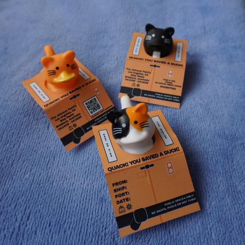 3 cat styled rubber ducks wearing cruising duck tags. Tags are looking like little life jackets.