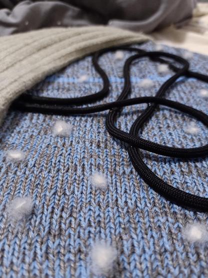 Macro photo of textile applique: white balls represented snowflakes are situated on the blue background