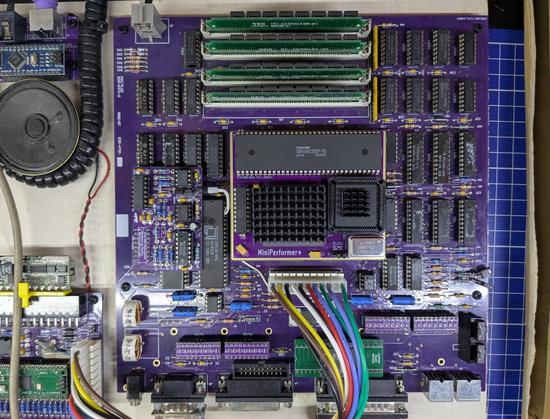Photo of the MiniPerformer+ installed on a clone Macintosh Plus motherboard. Photo from above. The motherboard is screwed to a wooden panel.