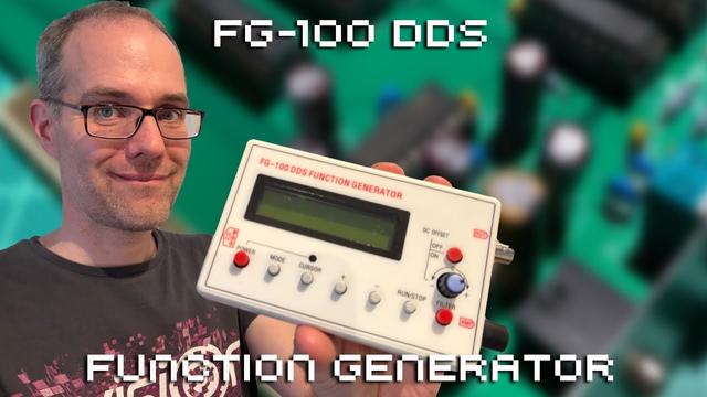 Me presenting a white plastic box with an LCD display and buttons