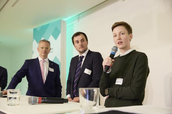 Rebecca Lenhard spricht, ihre beiden Gesprächspartner hören ihr zu