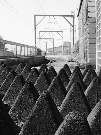 Black and White photo of rail spikes to discharge people from leaving the station and going on tracks.