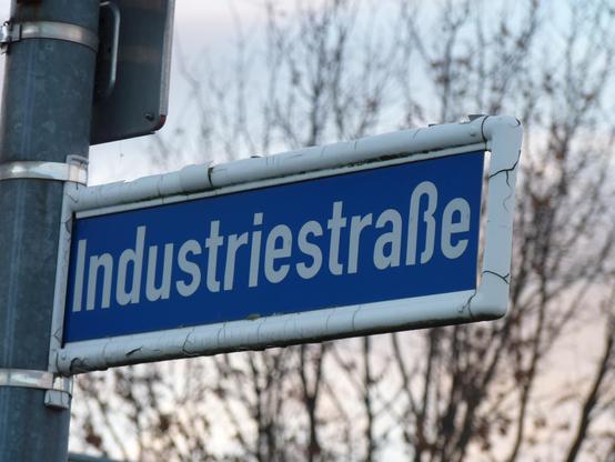 Das Foto zeigt ein Schild, auf dem "Industriestraße" steht.