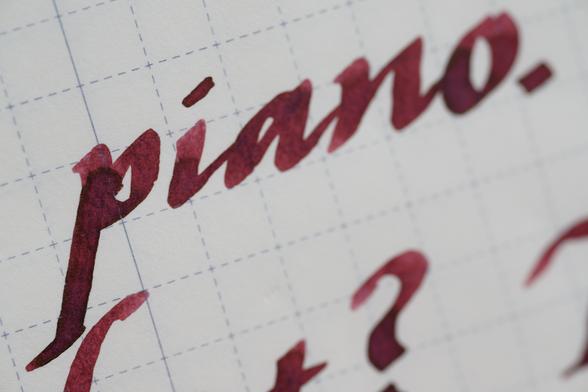 Word "piano" in red-brown mahogany-tone ink