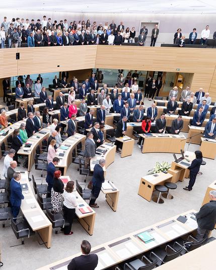 Die Abgeordneten und Gäste stehen zur Gedenkminute zu Beginn der 122. Plenarsitzung.
