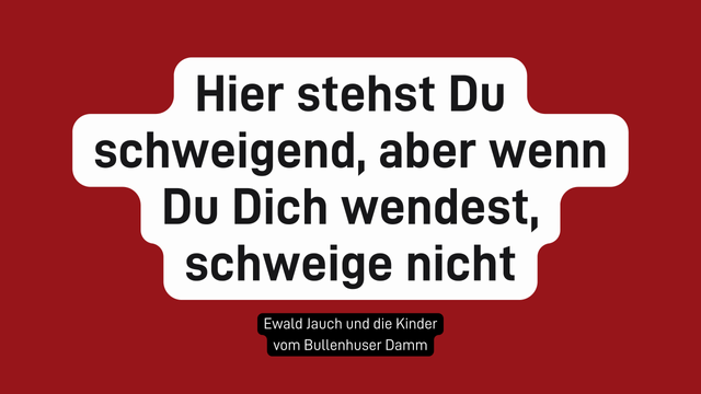 Weißer Textblock mit schwarzer Schrift auf dunkelrotem Hintergrund. In der Mitte steht: „Hier stehst Du schweigend, aber wenn Du Dich wendest, schweige nicht“. Darunter in kleinerer Schrift auf schwarzem Feld: „Ewald Jauch und die Kinder vom Bullenhuser Damm“.