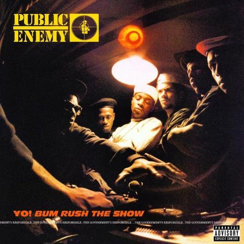 The cover art for the album 'Yo! Bum Rush The Show' by Public Enemy.

The image is a photo of the band members plus the S1Ws standing in a dark room under a single light. Some are looking to the left, and some are looking down at turntables at the bottom of the image. Flavor Flav (I think!) is on the left and reaching for the turntable.

The Public Enemy logo is at the top left in yellow, with the album title at the bottom left in red. Under the title in a typewriter font in white is 'THE GOVERNMENT'S RESPONSIBLE...' repeated along the full width of the cover. There is also a parental advisory logo at the bottom right.